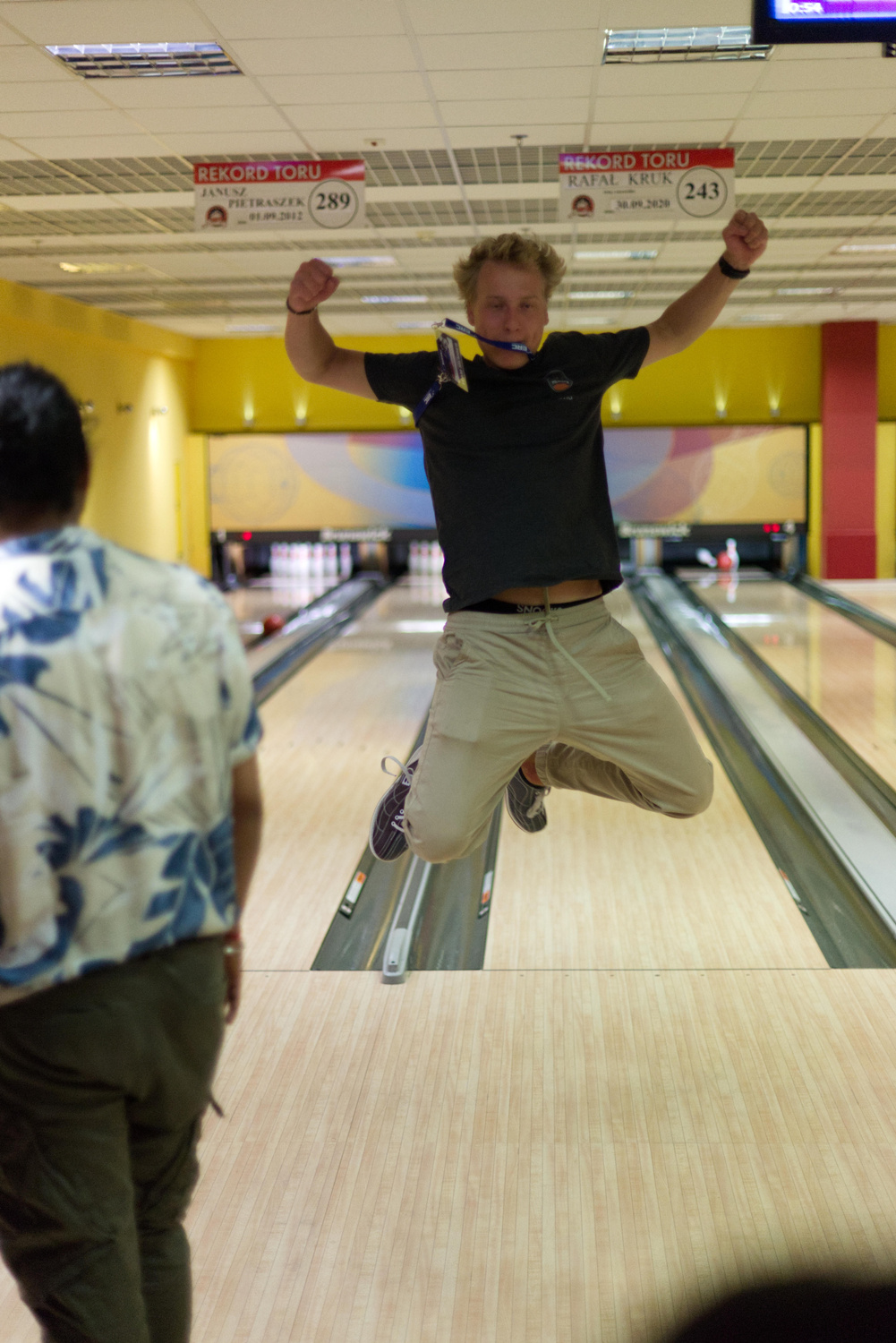 David springt in die Luft vor einer Bowling-Bahn.